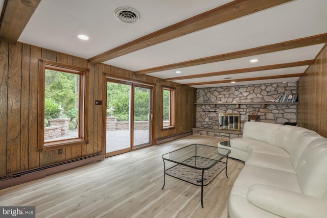 living room featuring a baseboard radiator, beamed ceiling, wooden walls, and light wood-type flooring