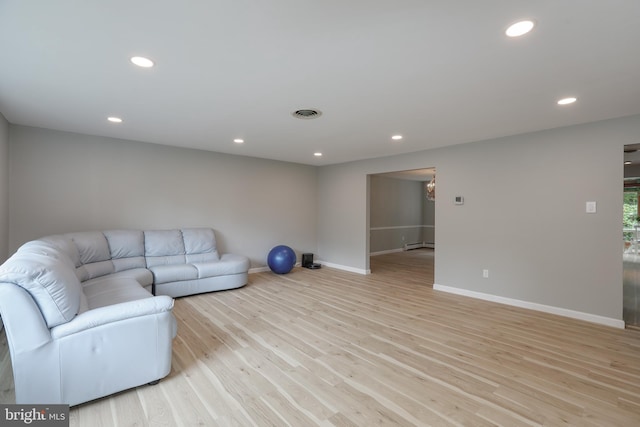 living room featuring baseboard heating and light hardwood / wood-style floors