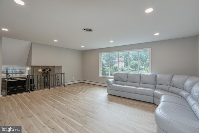 living room featuring light wood-type flooring and a baseboard heating unit