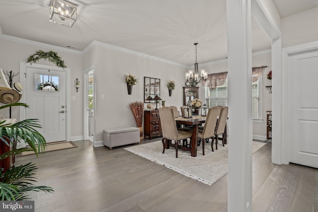 dining space featuring hardwood / wood-style flooring, crown molding, and a chandelier