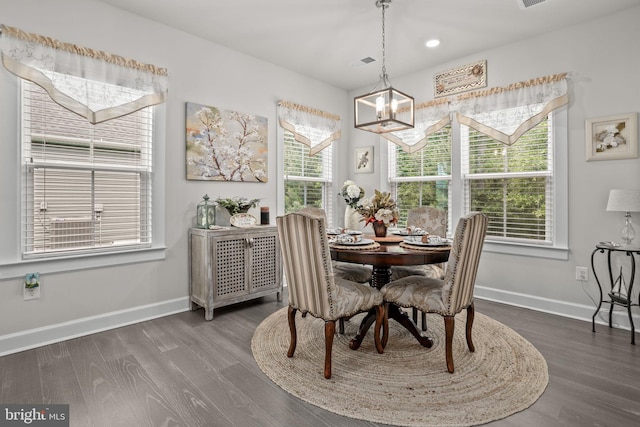 dining space with plenty of natural light, dark hardwood / wood-style floors, and a chandelier