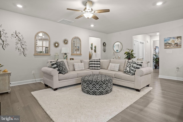 living room with dark hardwood / wood-style flooring and ceiling fan