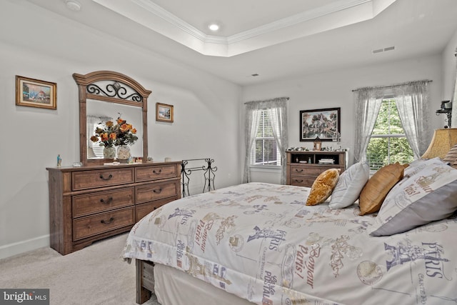 bedroom with a raised ceiling, ornamental molding, light carpet, and multiple windows