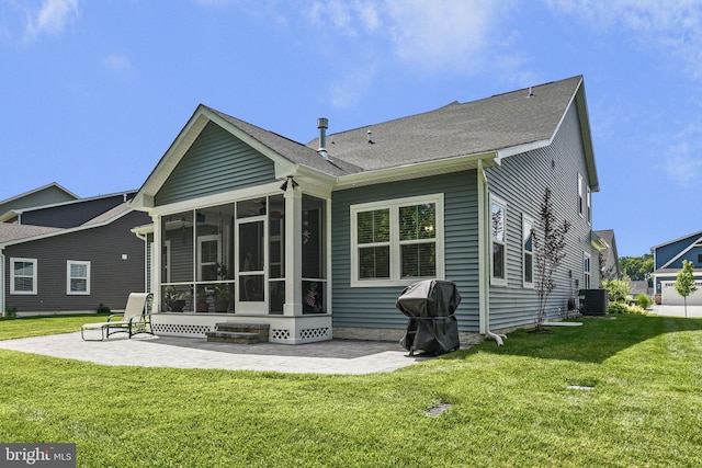 back of property with a sunroom, a yard, central air condition unit, and a patio area