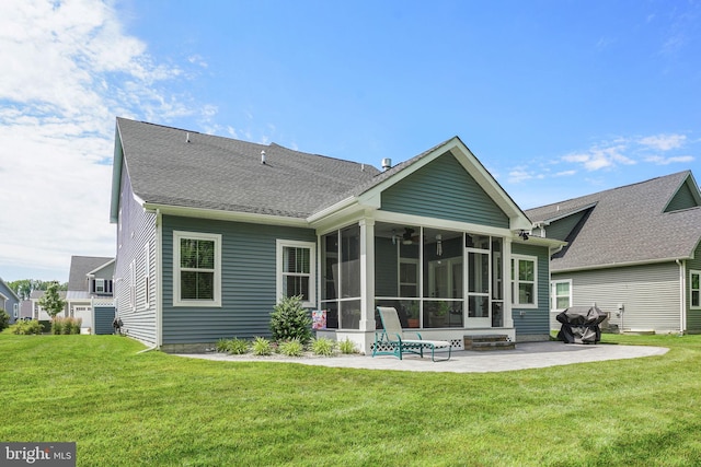 rear view of house featuring a patio area, a sunroom, and a lawn