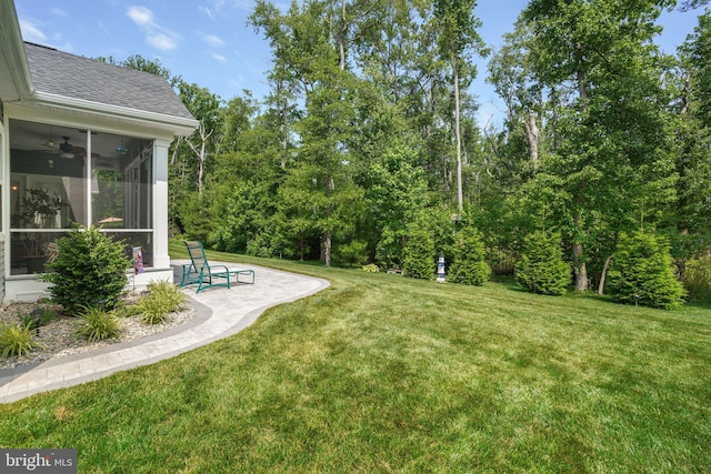 view of yard featuring a patio area, a sunroom, and ceiling fan