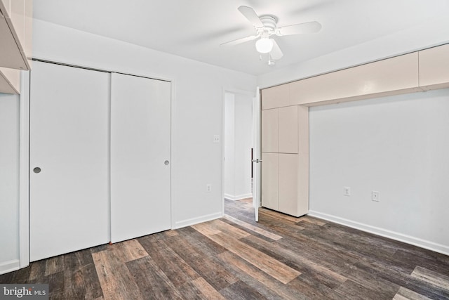 unfurnished bedroom with ceiling fan, dark hardwood / wood-style floors, and a closet