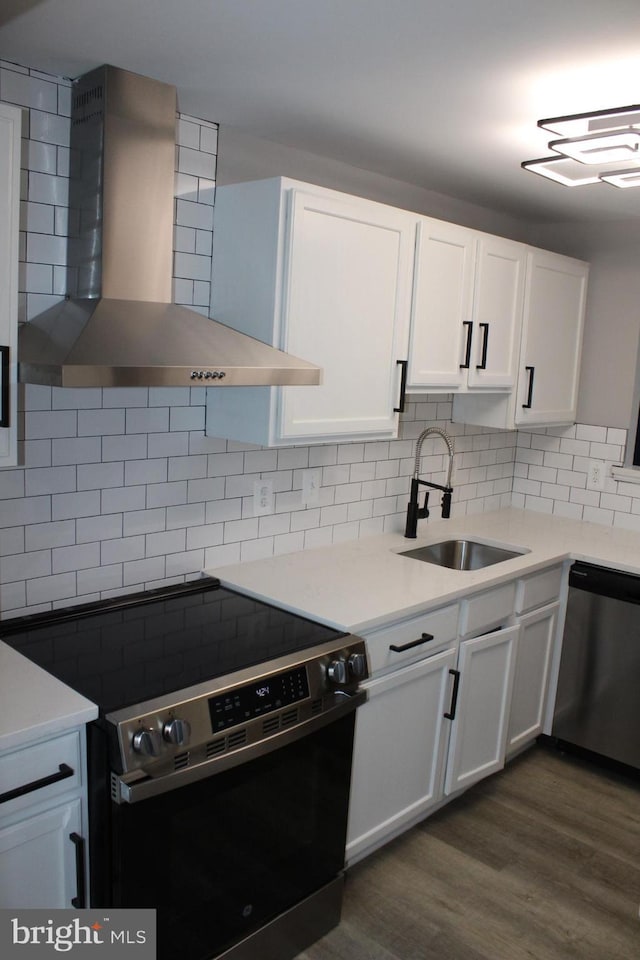 kitchen featuring white cabinetry, appliances with stainless steel finishes, sink, and wall chimney exhaust hood