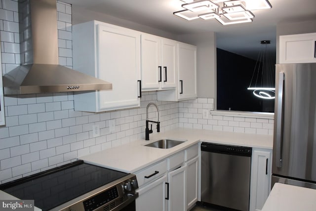 kitchen featuring wall chimney exhaust hood, stainless steel appliances, sink, and white cabinets