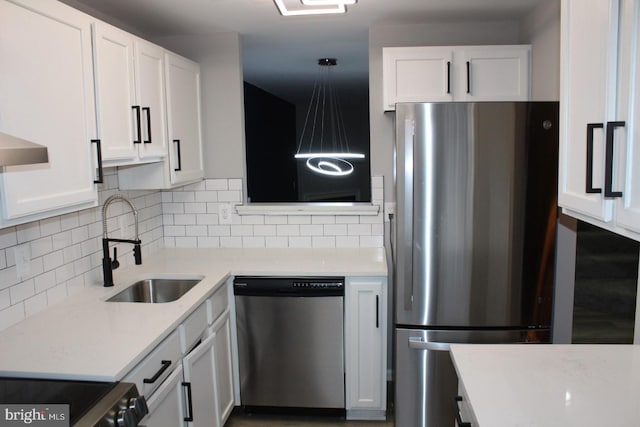 kitchen with pendant lighting, stainless steel appliances, sink, and white cabinets