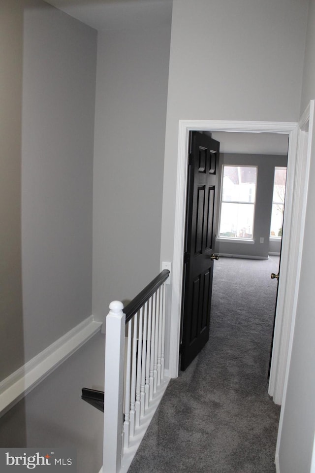 corridor featuring dark colored carpet