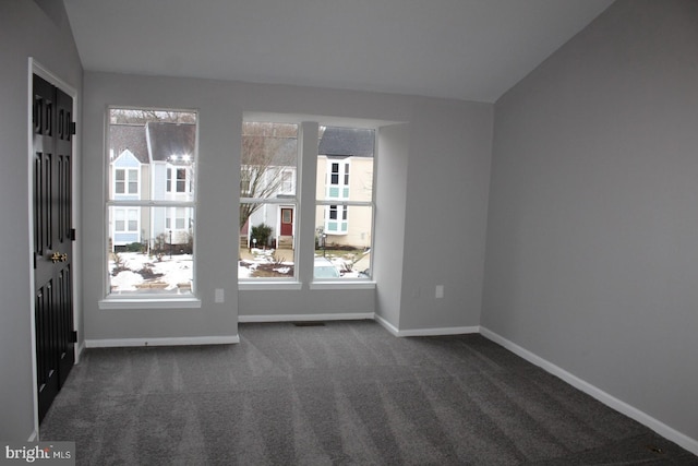 carpeted empty room featuring lofted ceiling