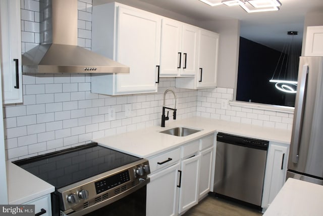 kitchen featuring white cabinets, wall chimney exhaust hood, and appliances with stainless steel finishes