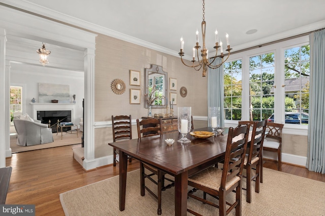 dining space featuring an inviting chandelier, crown molding, and hardwood / wood-style floors