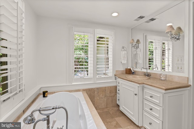 bathroom with vanity and tiled tub