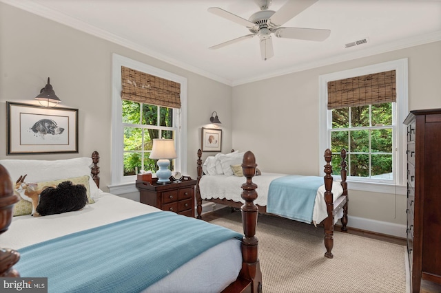 bedroom featuring ceiling fan, ornamental molding, hardwood / wood-style floors, and multiple windows