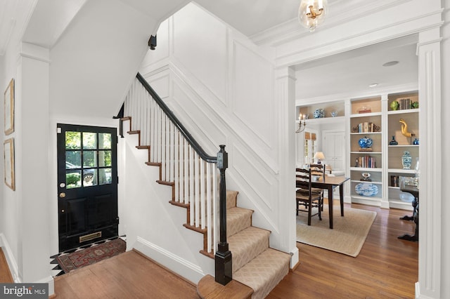 entryway with ornate columns and hardwood / wood-style floors