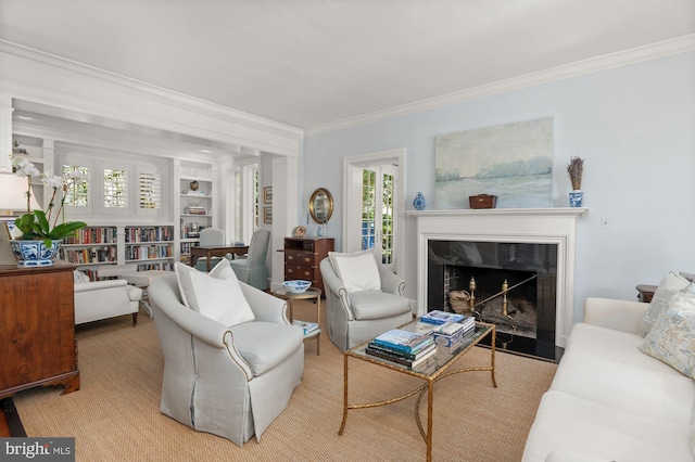 living room with crown molding, built in features, and a premium fireplace