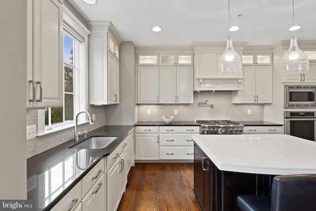 kitchen with sink, white cabinetry, plenty of natural light, appliances with stainless steel finishes, and pendant lighting