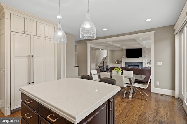 kitchen with a kitchen island, dark hardwood / wood-style floors, decorative light fixtures, coffered ceiling, and dark brown cabinets