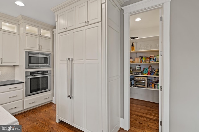 kitchen featuring tasteful backsplash, appliances with stainless steel finishes, dark hardwood / wood-style floors, and white cabinets