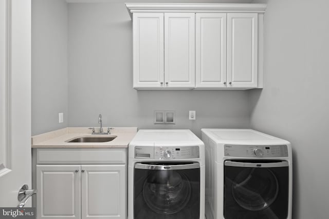 clothes washing area with cabinets, sink, and independent washer and dryer