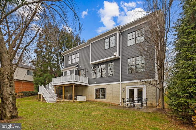 rear view of house featuring a patio, a yard, french doors, and a wooden deck