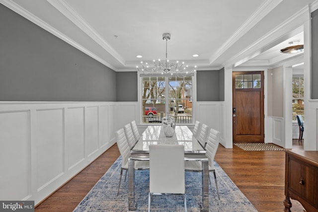 dining room featuring a notable chandelier, a tray ceiling, ornamental molding, and dark hardwood / wood-style floors