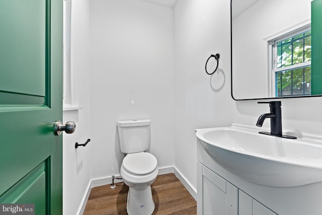 bathroom with vanity, wood-type flooring, and toilet