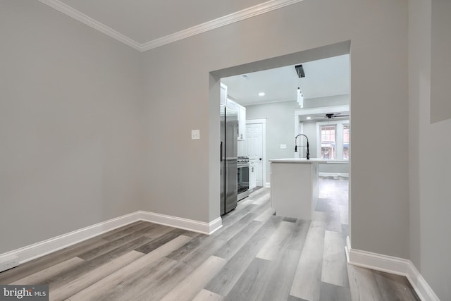 corridor with ornamental molding, sink, and light hardwood / wood-style floors