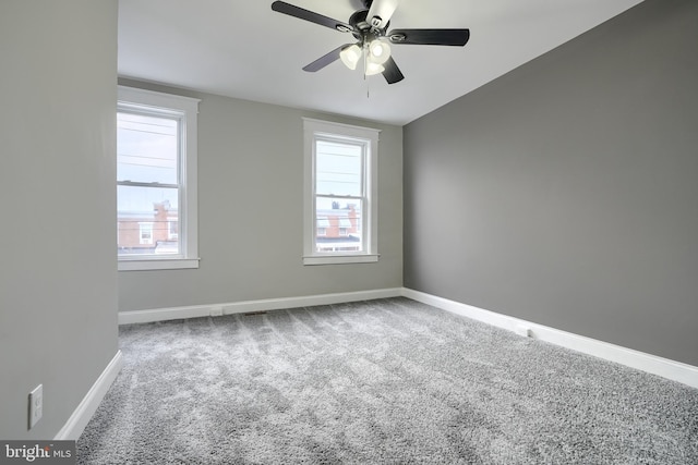 empty room with carpet floors, plenty of natural light, and ceiling fan