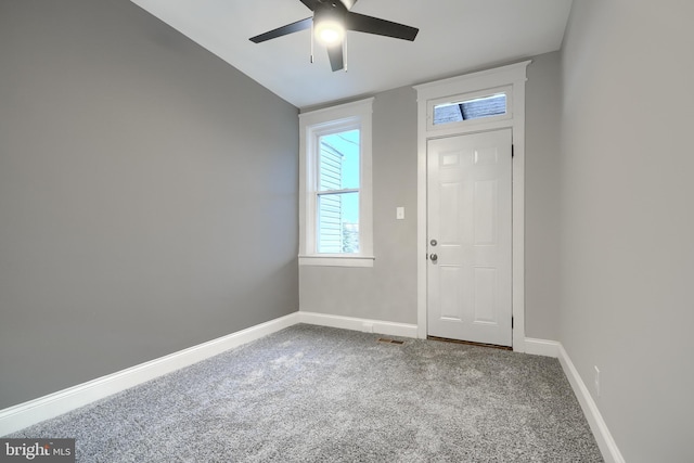 foyer entrance with carpet floors and ceiling fan