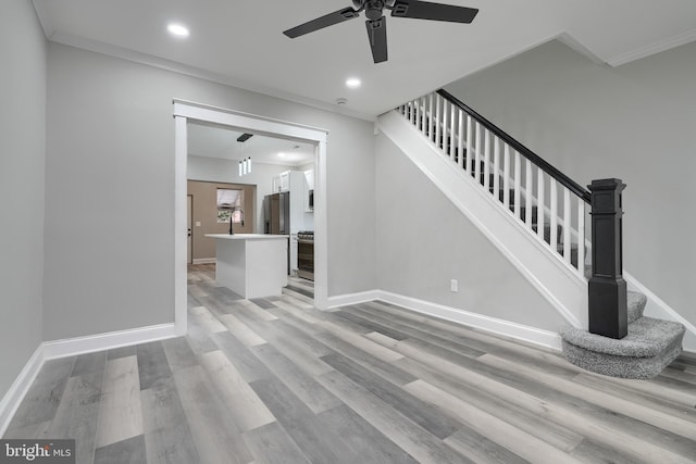 unfurnished living room with ornamental molding and light wood-type flooring