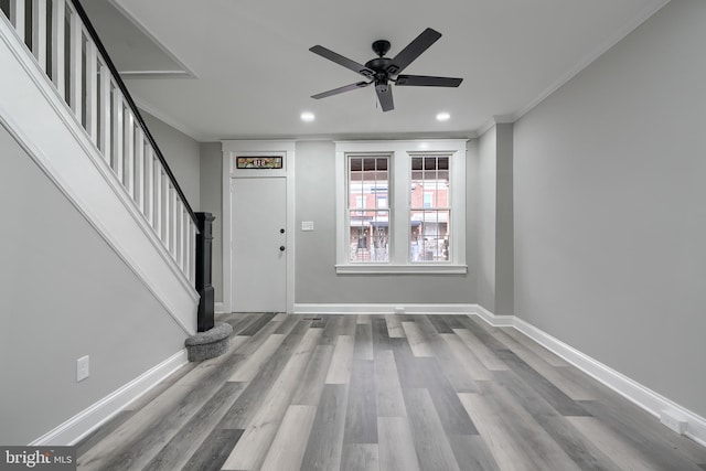 foyer featuring ornamental molding, ceiling fan, and light wood-type flooring