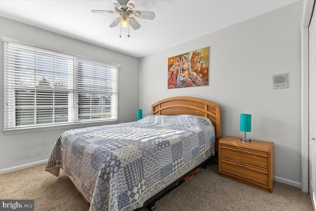 carpeted bedroom with ceiling fan and baseboards