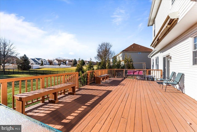 wooden terrace featuring fence and a lawn