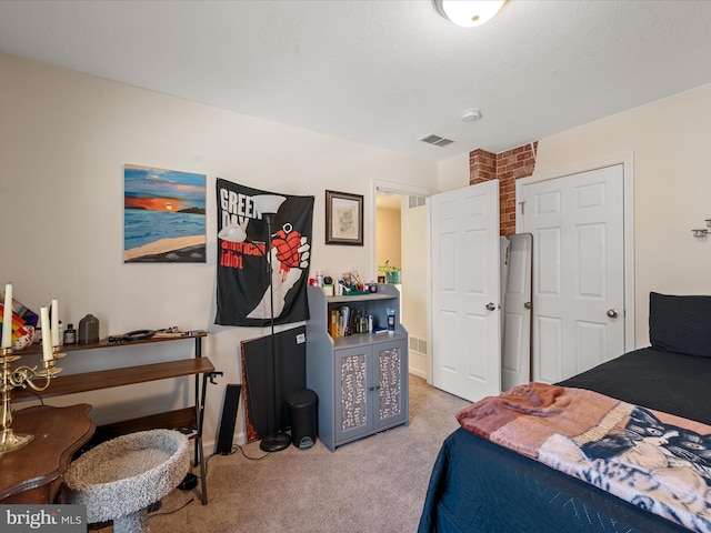 bedroom featuring light carpet and a textured ceiling