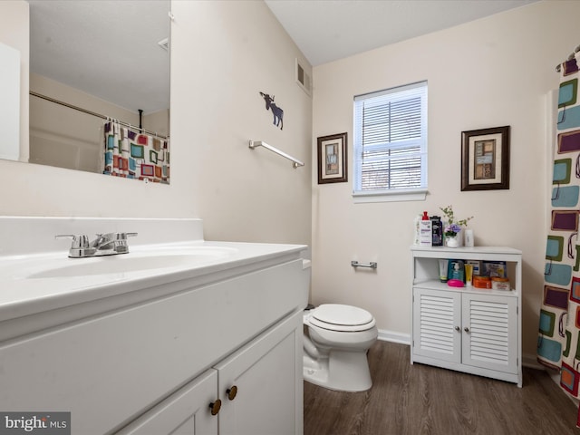 bathroom with vanity, hardwood / wood-style floors, and toilet