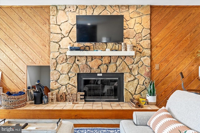 living room featuring a stone fireplace and wooden walls