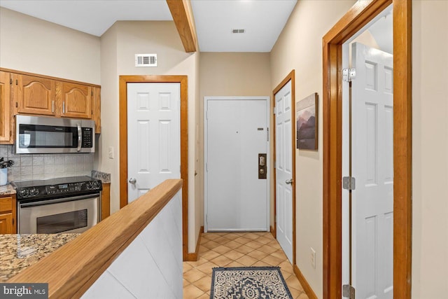 kitchen featuring appliances with stainless steel finishes, decorative backsplash, and light tile patterned floors