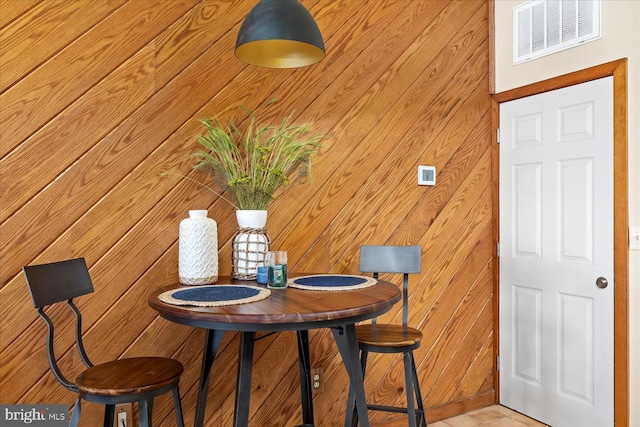 dining space featuring wooden walls