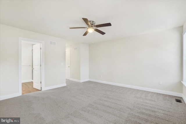 carpeted spare room featuring ceiling fan