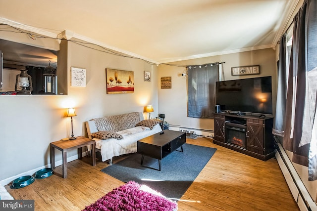 living room with crown molding, a baseboard heating unit, and hardwood / wood-style floors