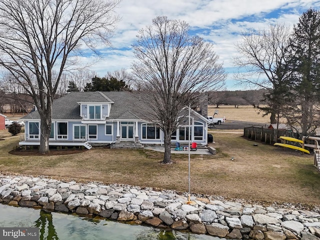 view of front facade with a front yard and a sunroom