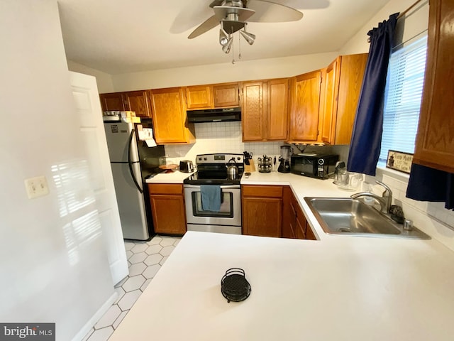 kitchen featuring ceiling fan, stainless steel appliances, sink, and backsplash