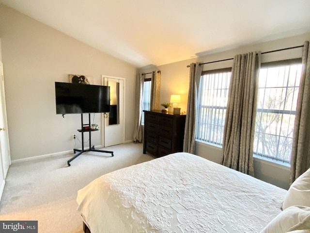 bedroom with vaulted ceiling and light carpet