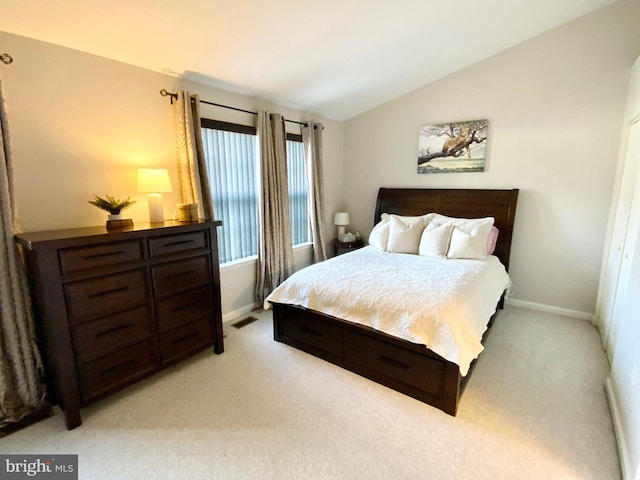 bedroom featuring lofted ceiling and light carpet