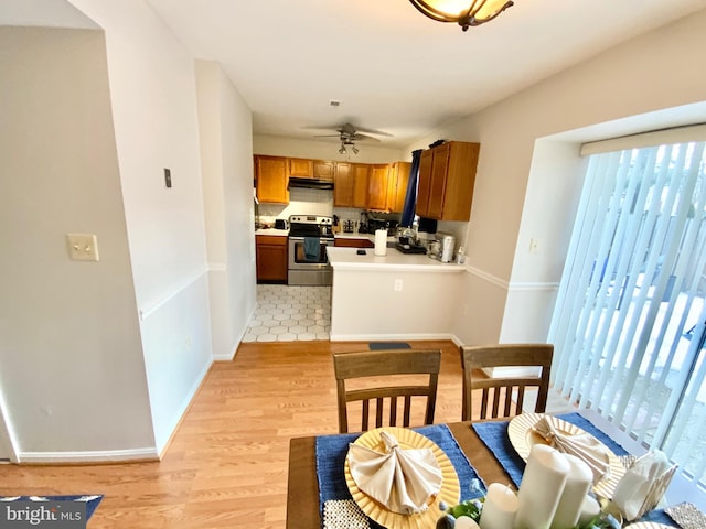 kitchen featuring electric range, light hardwood / wood-style floors, and ceiling fan