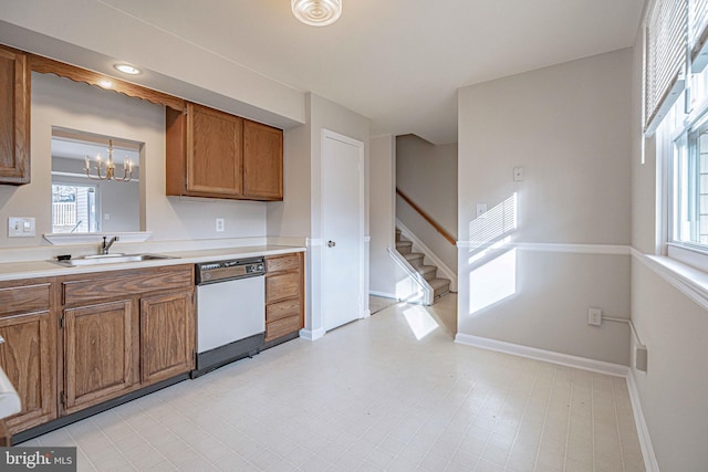 kitchen featuring an inviting chandelier, a healthy amount of sunlight, sink, and white dishwasher