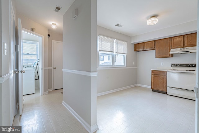 kitchen with washer / clothes dryer and white range with electric cooktop